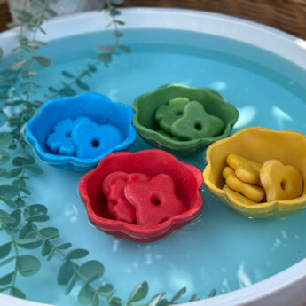 flower stones is matching colored bowls floating on water