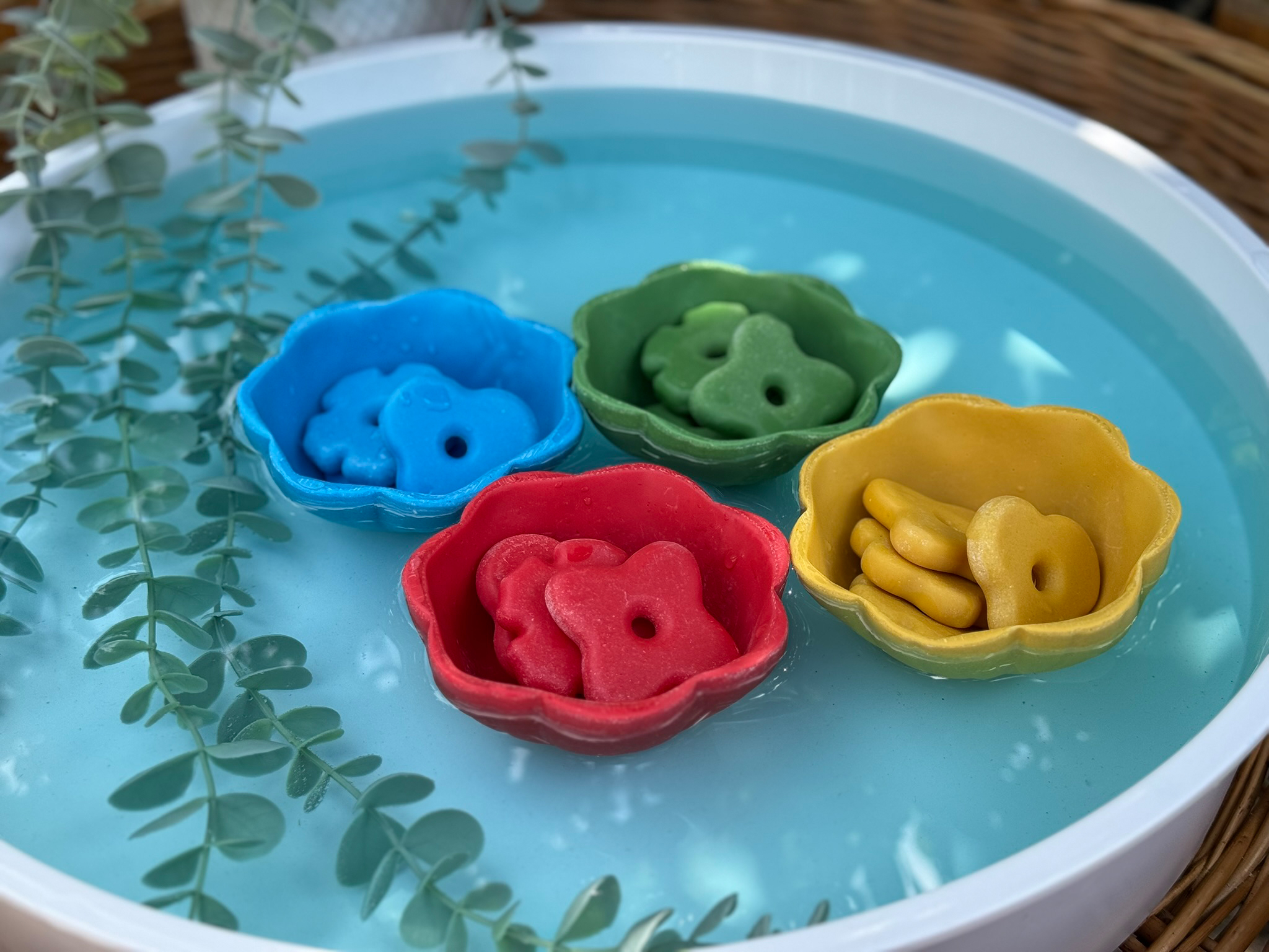 flower stones is matching colored bowls floating on water